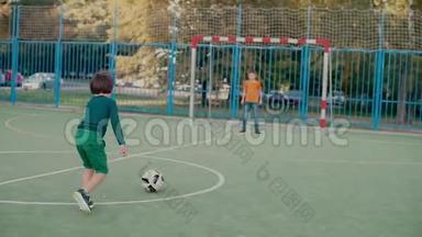 一个小学生在球门上踢足球，另一个小学生接住球